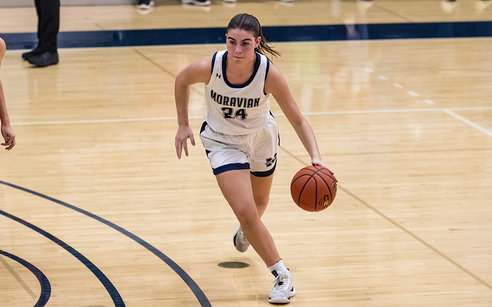 Freshman guard/forward Lizzie Lustig dribbles at the top of the key in the first half versus The Catholic University of America in Johnston Hall earlier this season. Photo by Cosmic Fox Media / Matthew Levine '11