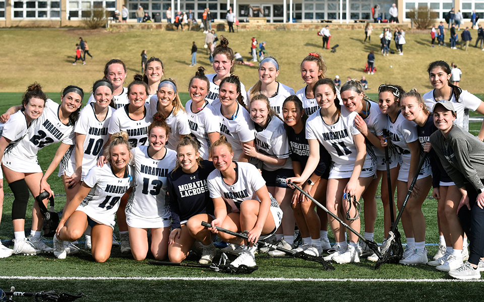 The Greyhounds with Head Coach Caroline Pape (far right) after her first career victory with Moravian's 16-12 win over The United States Coast Guard Academy on John Makuvek Field. Photo by Marissa Werner '23