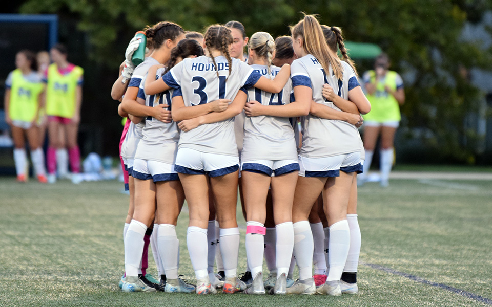 The Greyhounds huddle before taking on No. 5 Misericordia University on John Makuvek Field this season. Photo by Emma Kressler '27