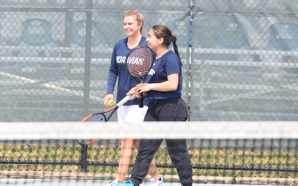 Junior Eiman Nazif and sophomore Emma Angle celebrate winning a point in doubles action versus Goucher College at Hoffman Courts.
