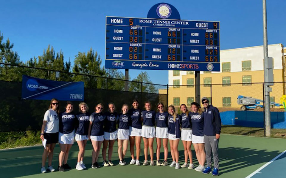 The Greyhounds in front of the scoreboard at the Rome (Ga.) Tennis Center after rallying to defeat Transylvania (Ky.) University in the NCAA Division III Tournament First Round.