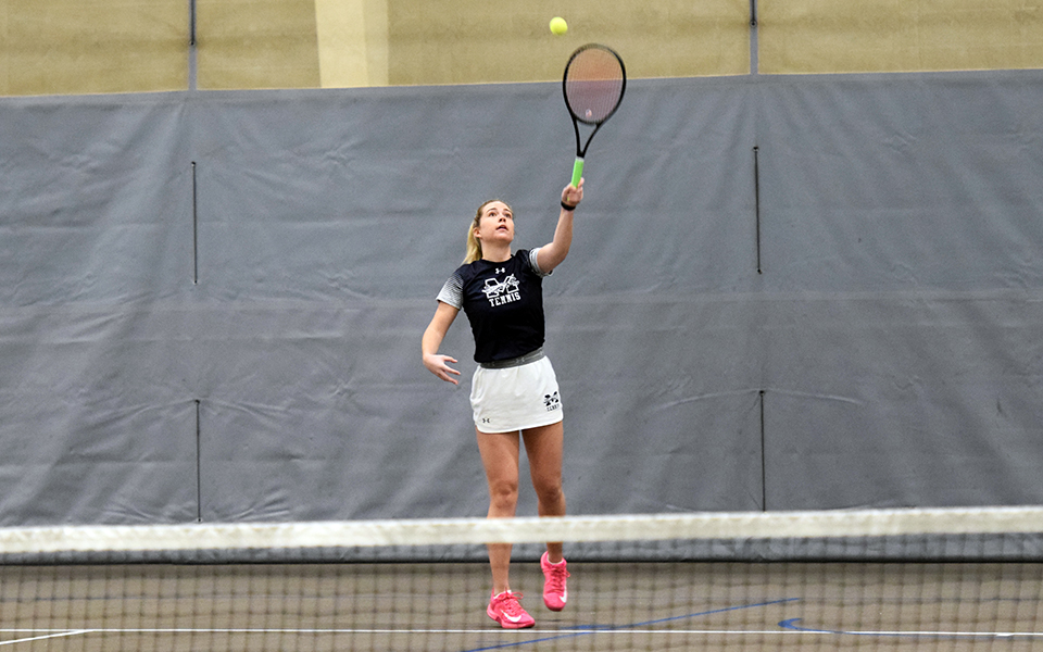 Senior Morgan Colver serves during doubles action inside of Timothy Breidegam Field House versus Bryn Mawr College.