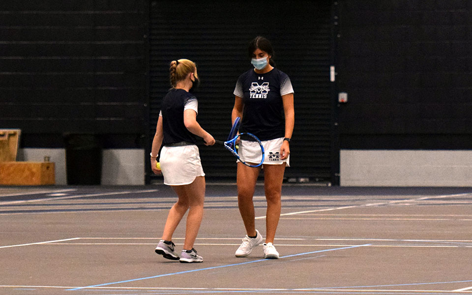 Cristina Merone and Julianne Cassady talk during doubles action in the 2021 Landmark Conference Championship match in Timothy Breidegam Fieldhouse in May.