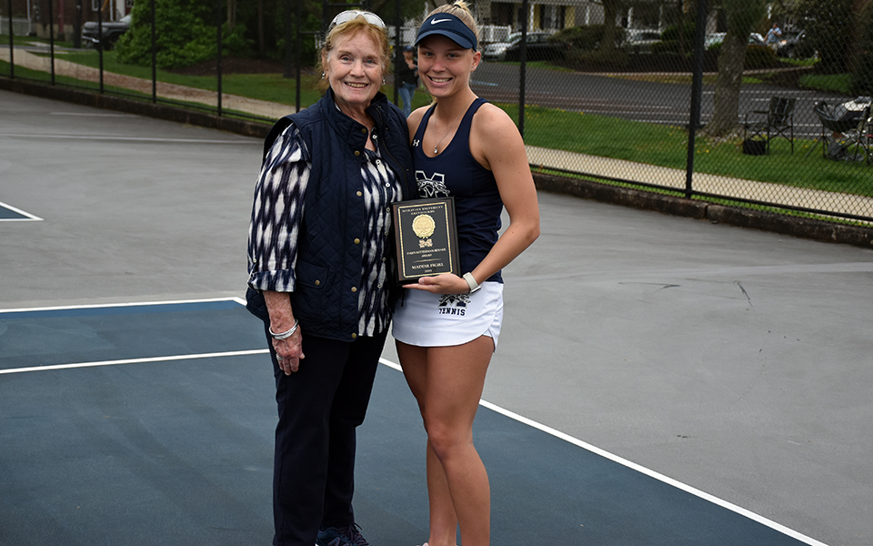 Former Head Coach Dawn Ketterman-Benner presents senior Maddie Figiel with the inaugural Dawn Ketterman-Benner Award for dedication to the women's tennis program prior to the Greyhounds final regular season match with Kean University at Hoffman Courts. Photo by Christine Fox