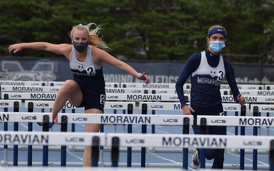 Cat Cole '21 and Alyssa Lambert '22 compete in the 100-meter hurdles during the Coach P Invitational at Timothy Breidegam Track.