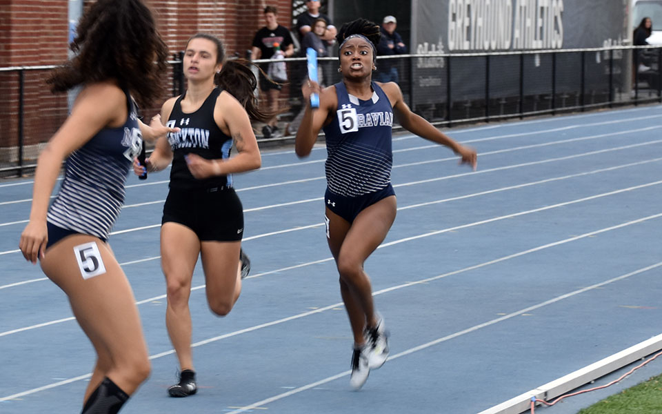 Freshman Zoey Bronson gets set to pass off the baton to junior Crystal Robinson in the 4x400-meter relay at the 2022 All-Atlantic Region Outdoor Track & Field Championships at Timothy Breidegam Track. Photo by Christian Jancsarics '23