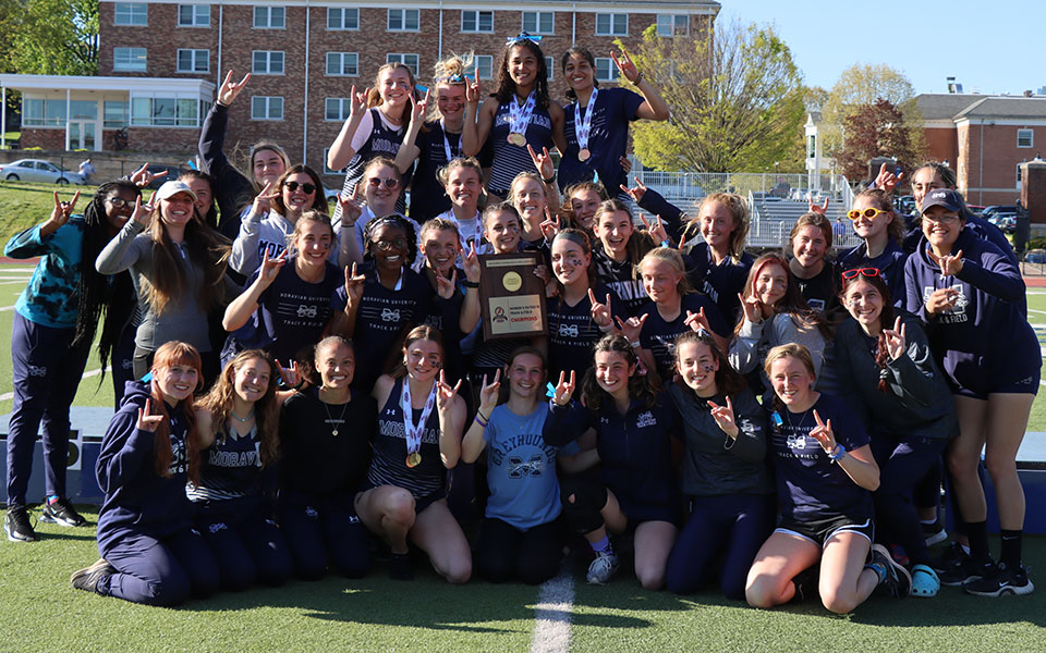 The Greyhounds celebrate on the podium after winning the 2022 Landmark Conference Outdoor Championship by a point at Juniata College. Photo courtesy of Juniata Athletic Communications