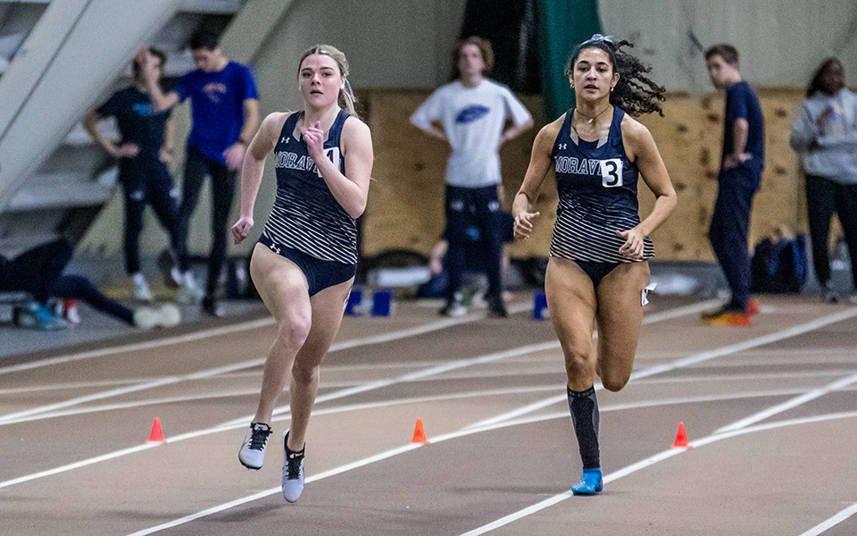 Sophomore Abby Giamoni and senior Crystal Robinson run in a sprint race during the Moravian Indoor Meet at Lehigh University's Rauch Fieldhouse earlier this season. Photo by Cosmic Fox Media / Matthew Levine '11