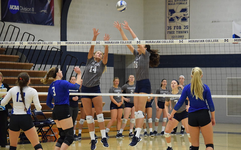 Sela Herber and Renee Mapa on a block attempt versus Elizabethtown College in Johnston Hall during the 2018 season.