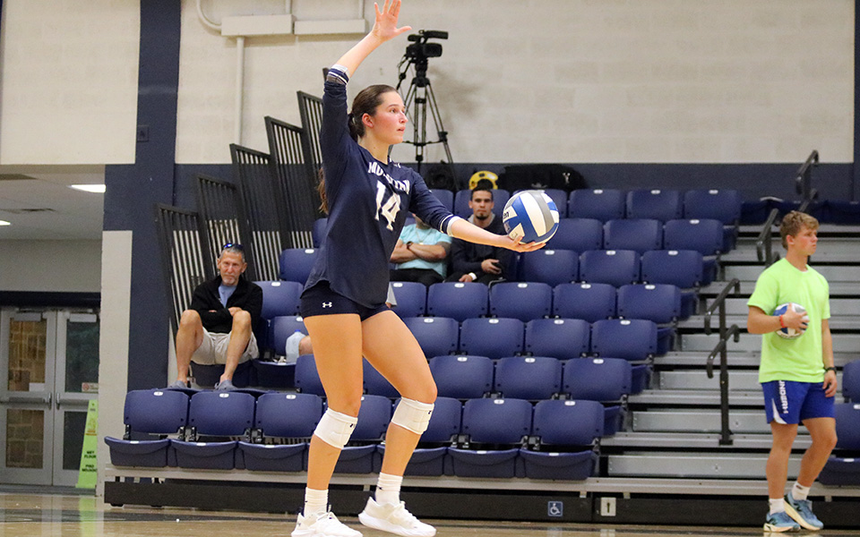 Freshman middle blocker Kate McBrierty gets set to serve versus DeSales University in Johnston Hall. Photo by Lia Logaivau '28