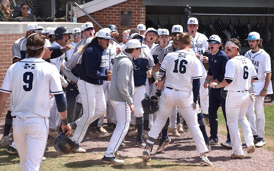 The Greyhounds celebrate freshman catcher Wyatt Harrar (#16) after a grand slam in the opener versus The Catholic University of America at Gillespie Field. Photo by Abby Smith '27