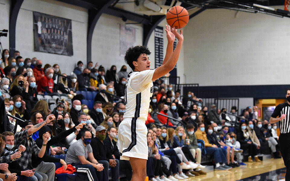 Freshman Nate Santiago shoots a three-pointer in the first half versus The Catholic University of America in Johnston Hall. Photo by Mairi West '23