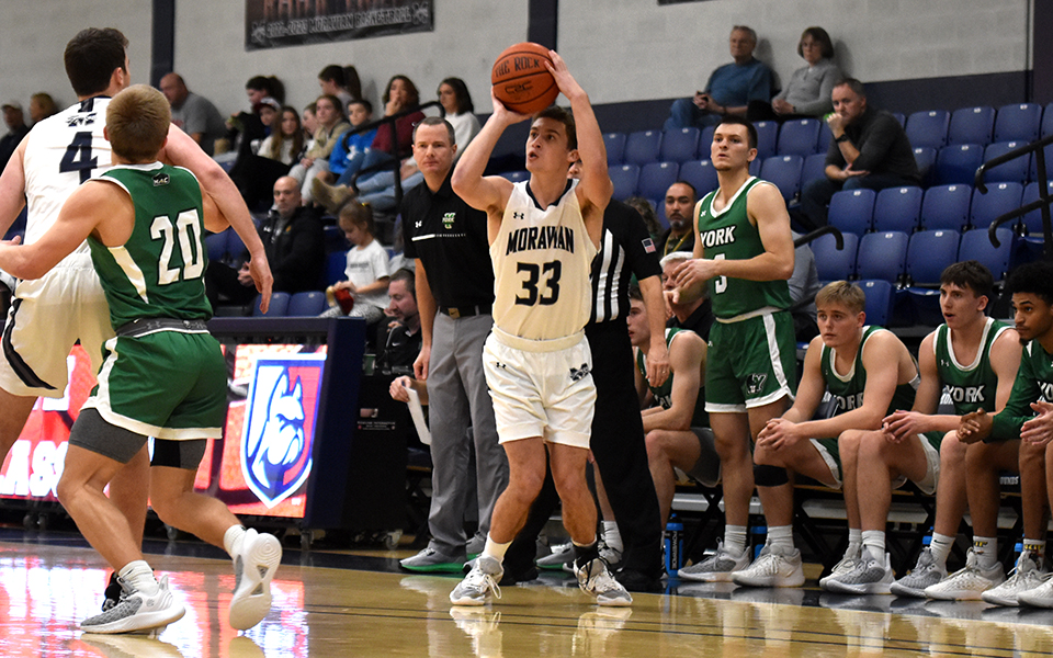 Junior guard Alex Dietz shoots a three-pointer during the first half of the championship game at the 42nd Steel Club Classic versus York College of Pennsylvania in Johnston Hall. Photo by Mairi West '23