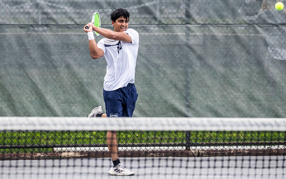 Sophomore Shayaan Farhad hits a backhand in singles action versus Alvernia University at Hoffman Courts. Photo by Cosmic Fox Media / Matthew Levine '11