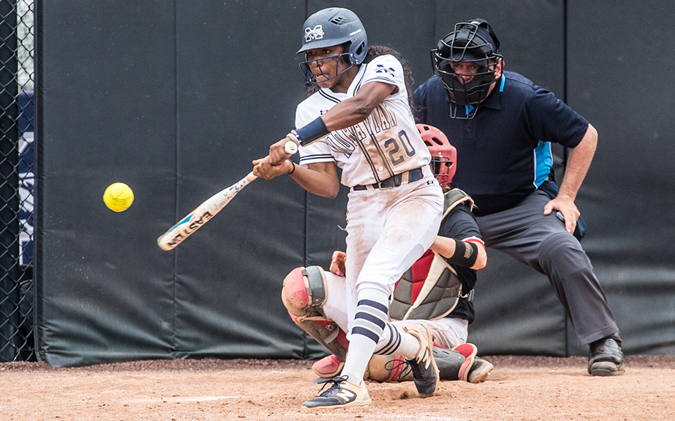 Junior shortstop Ajala Elmore connects with a pitch at Blue & Grey Field during a doubleheader with The Catholic University of America. Photo by Cosmic Fox Media / Matthew Levine '11
