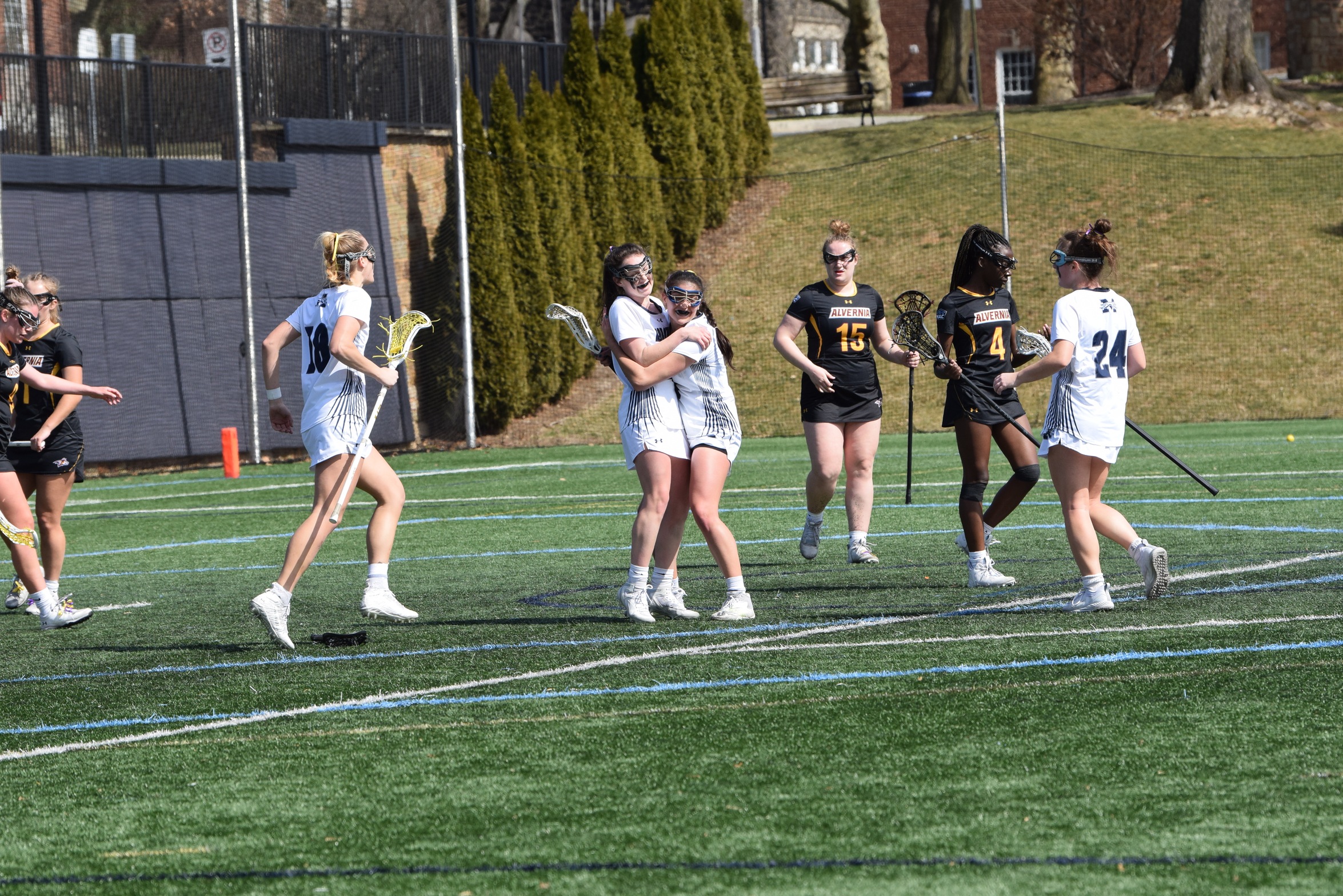 The Greyhounds celebrate sophomore attack Jackie Salvatore's 100th career point on a goal in the first half versus Alvernia University on John Makuvek Field. Photo by Marissa Williams '26