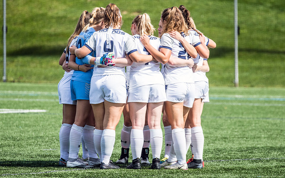 The 2021 women's soccer team huddled up prior to first whistle against Goucher College on Senior Day. (Photo by Cosmic Fox Media)