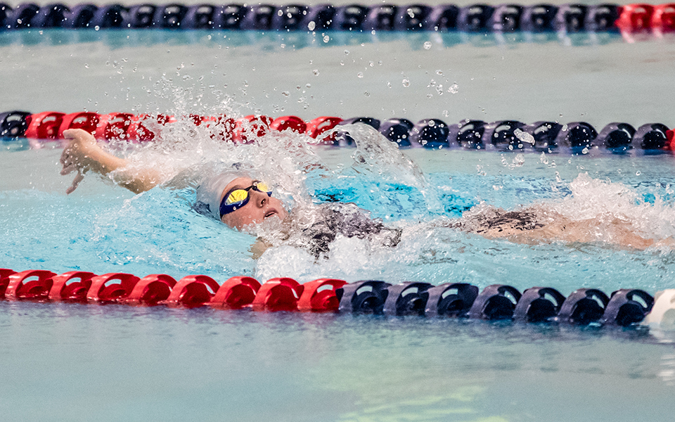 Junior Catie Lovett swims the backstroke in a dual meet versus William Paterson University at Liberty High School's Memorial Pool. Photo by Cosmic Fox Media / Matthew Levine '11