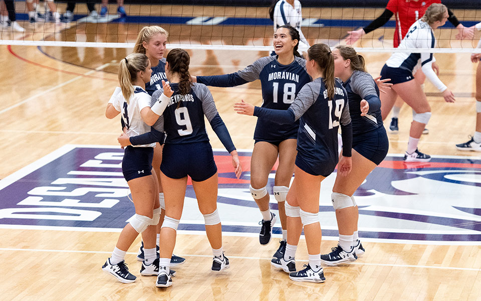 The Greyhounds celebrate a point in the 2021 season opener at DeSales University. Photo courtesy of Pat Jacoby Photography